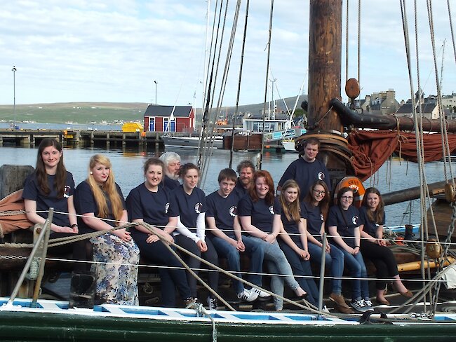 Back left to right: Peter Campbell, Chairman, Sail Training Shetland; Richard Pattison, Skipper; Scott Sandison, Bosun. Front left to right are sail trainees Eve Maguire; Laura Hampton; Emma Cockerill; Valerie Robinson; Steven Anderson; Georgia Leask; Molly Brindley; Diana Inkster; Kate Tyler and Ailish Parham. Missing from the photo are Orren Holt; Michaela Peterson; Heather Gray and Thomas Meadows.