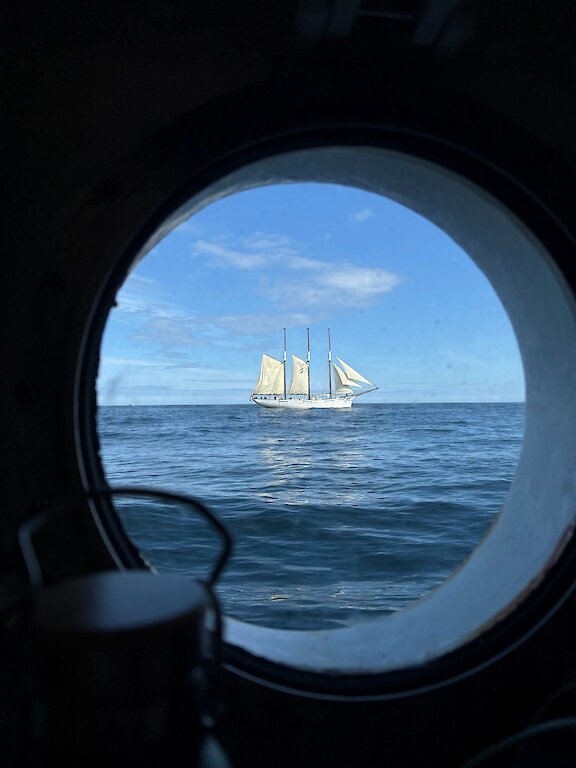 Looking out a port hole to a fellow ship
